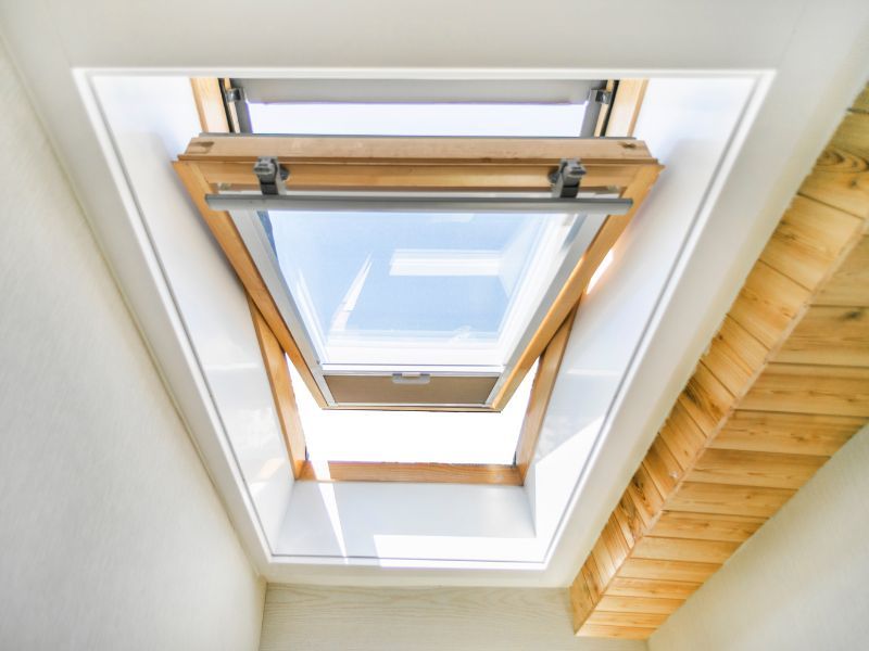 Looking up at a skylight in a room with a wooden ceiling.