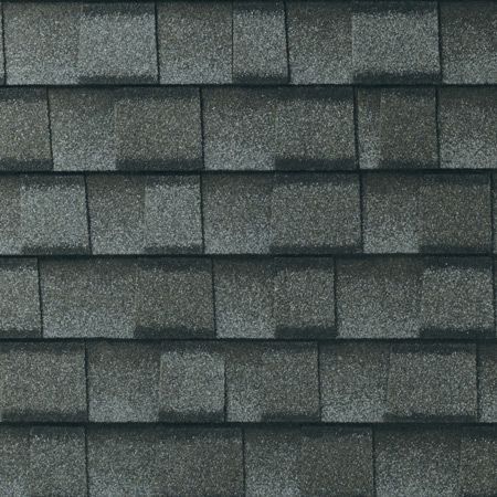 A close up of a row of gray shingles on a roof.