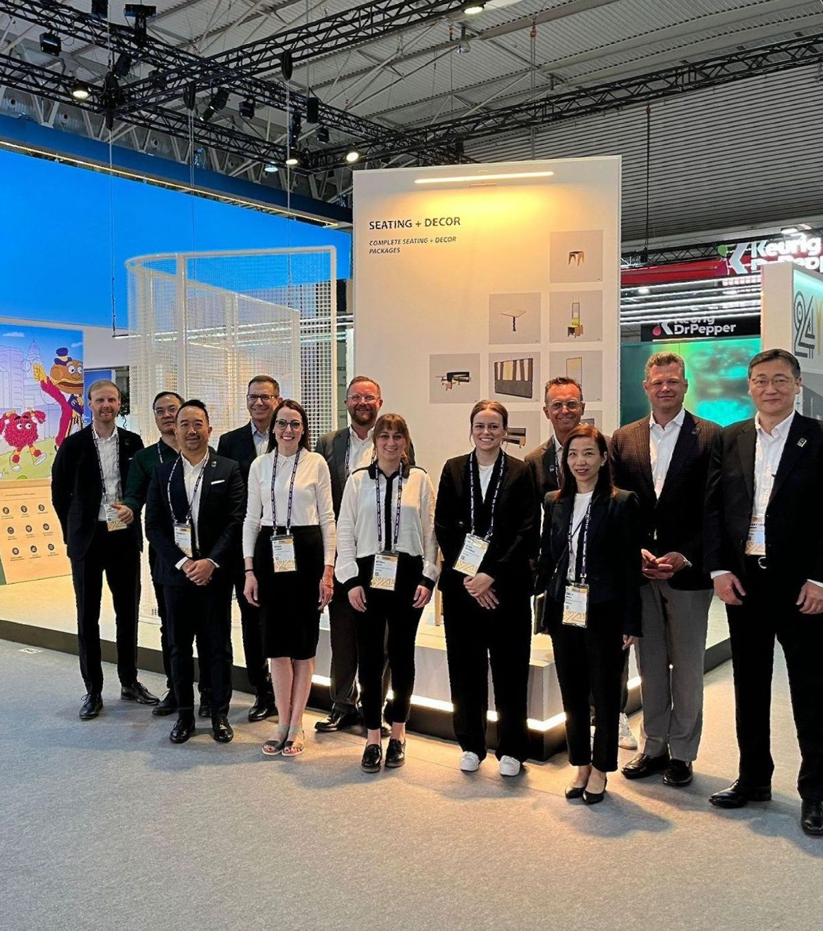 Gruppenbild vor dem EIS Messestand auf der McDonald's Messe in Barcelona. Unser Team besteht aus Projektleitern, Bauleitern, Kalkulator, Einkäufer, Architekt, Innenarchitekt und vieles mehr. Wir stellen ein! Offene Jobs im Bauunternehmen