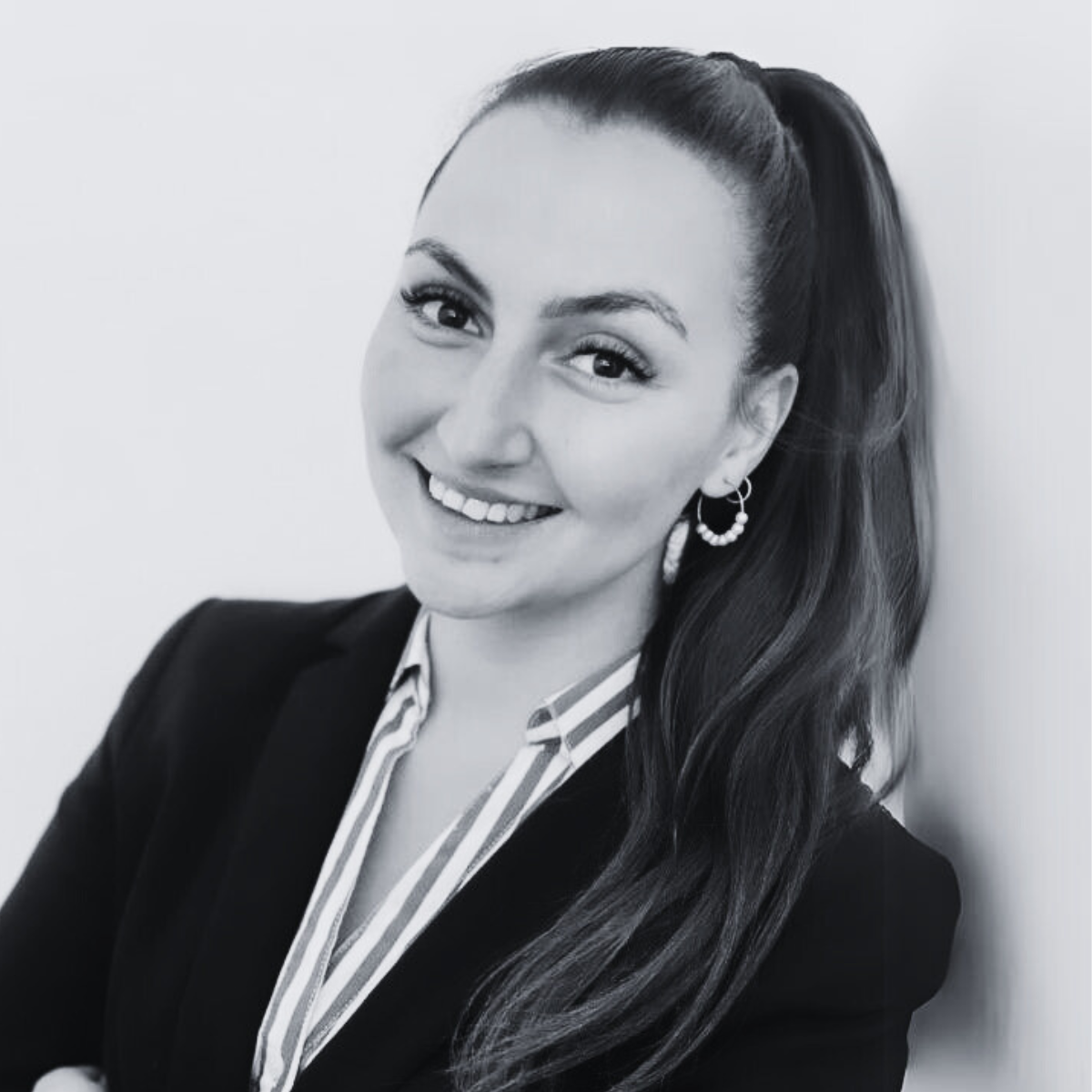 Portraitfoto Firmenfoto einer Mitarbeiterin in schwarz weiß lächelnd im Anzug