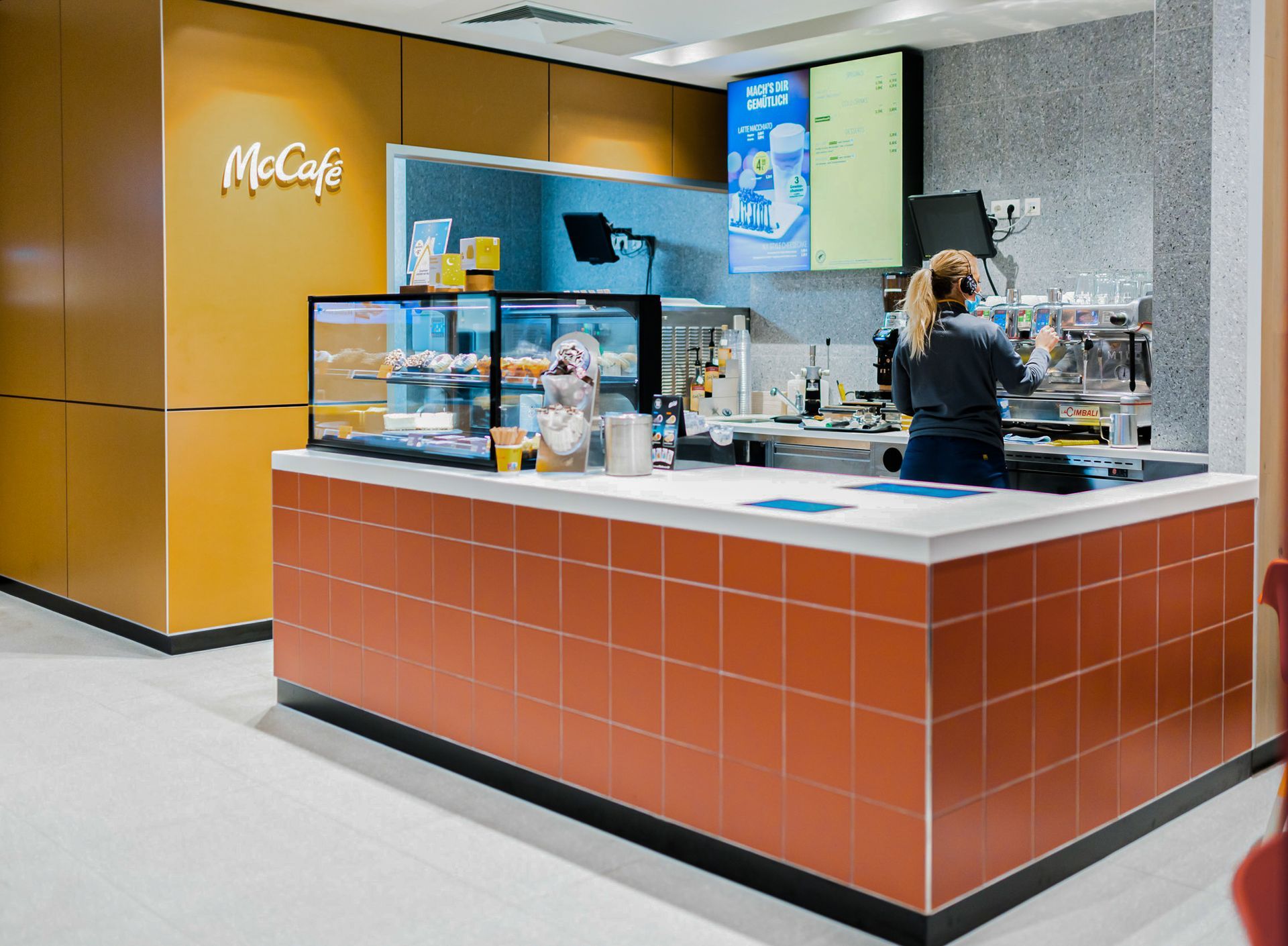 McDonald's Human Comfort Kaiserslautern - modernen Fast-Food-Restaurant mit McCafé mit orangen Fließen, brauner Wandverkleidung - Referenzprojekt Generalunternehmer Innenausbau