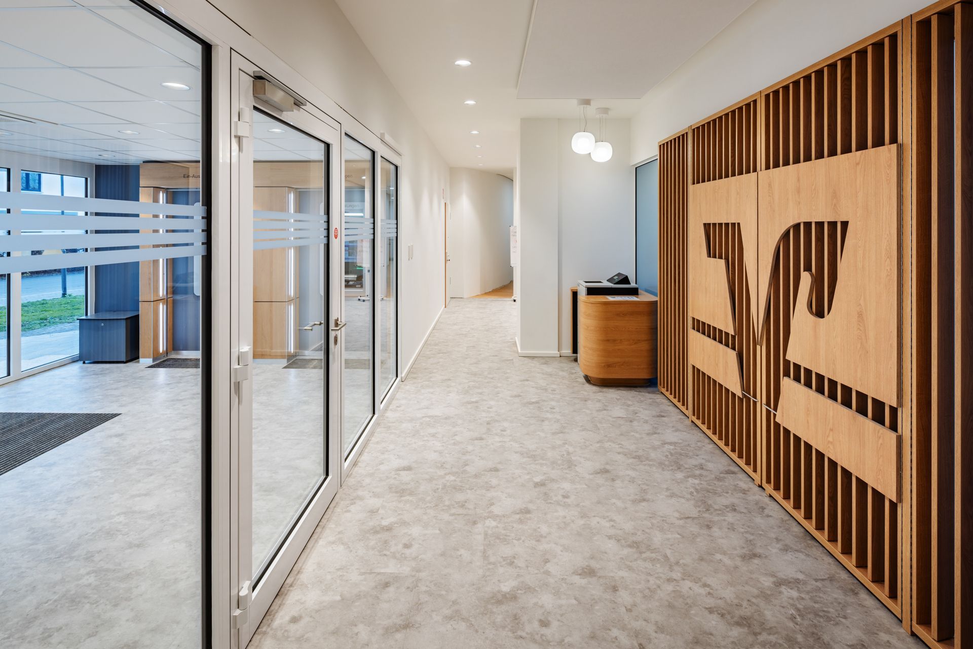 Moderner Büroumbau von EIS Aschaffenburg als Generalunternehmer - Büroeingang mit modernen Holzelementen und Wandverkleidung aus Schreinerei - Büroprojekt Referenz Elkay Interior Systems GC