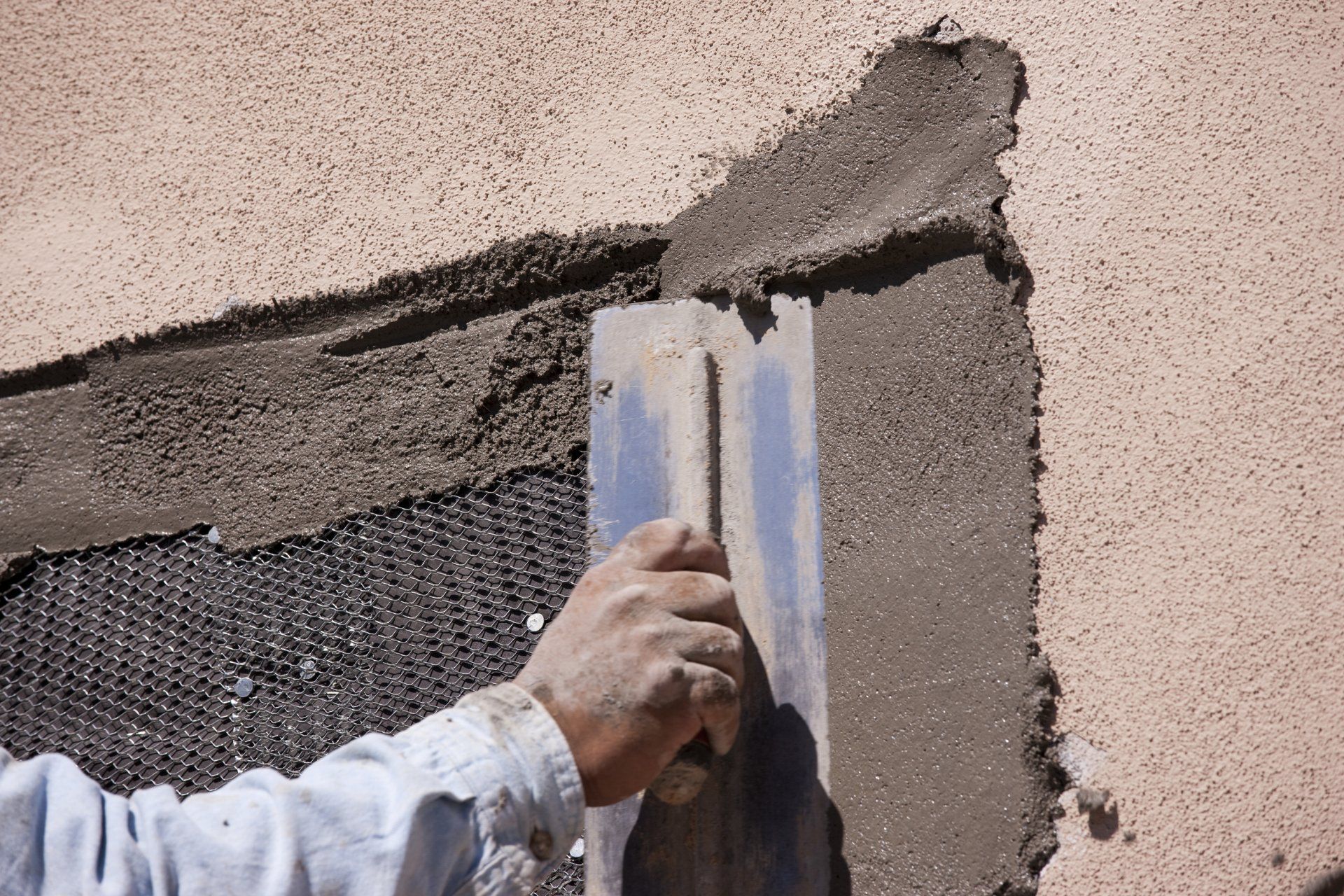man repairing stucco on a home in mesa az