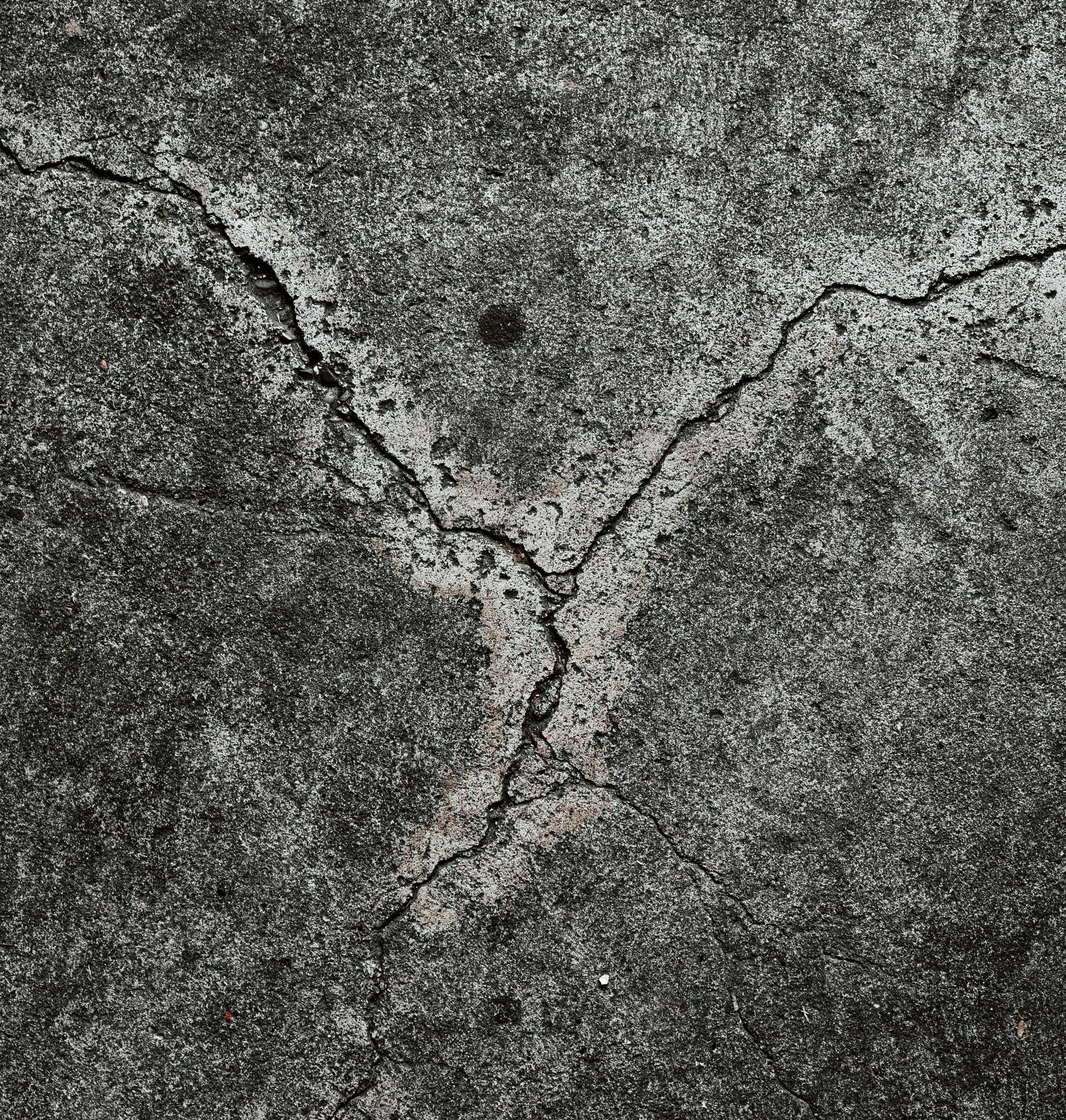 Cracked, gray concrete surface with a prominent Y-shaped fissure.
