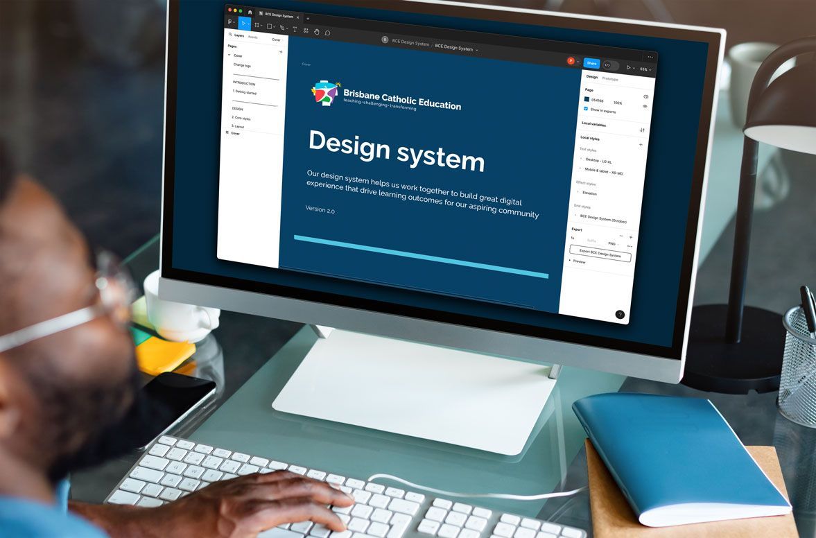 A man is sitting at a desk using a computer to view the BCE Design System.