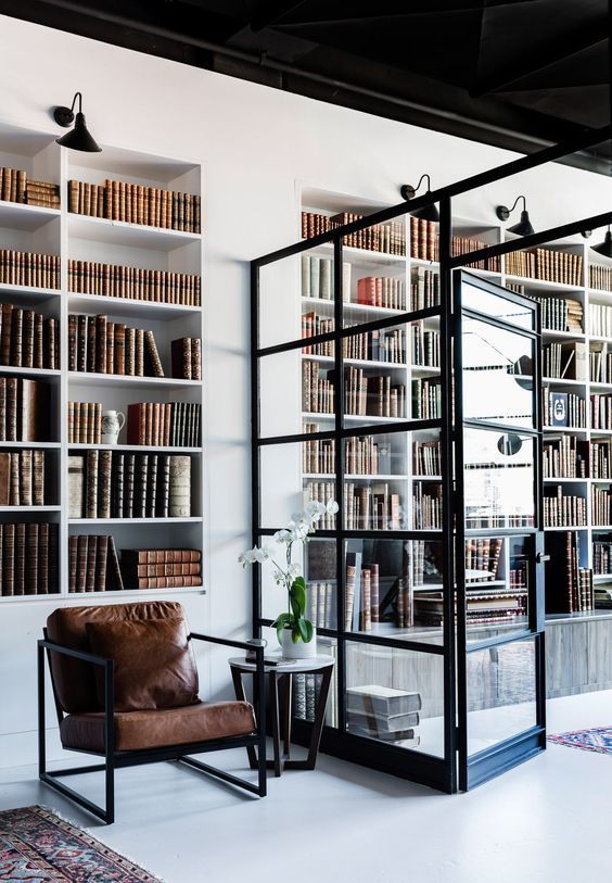 O cameră de zi cu un scaun și rafturi de cărți