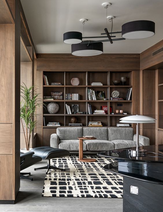 O sufragerie cu o canapea, scaun, masă și raft pentru cărți.