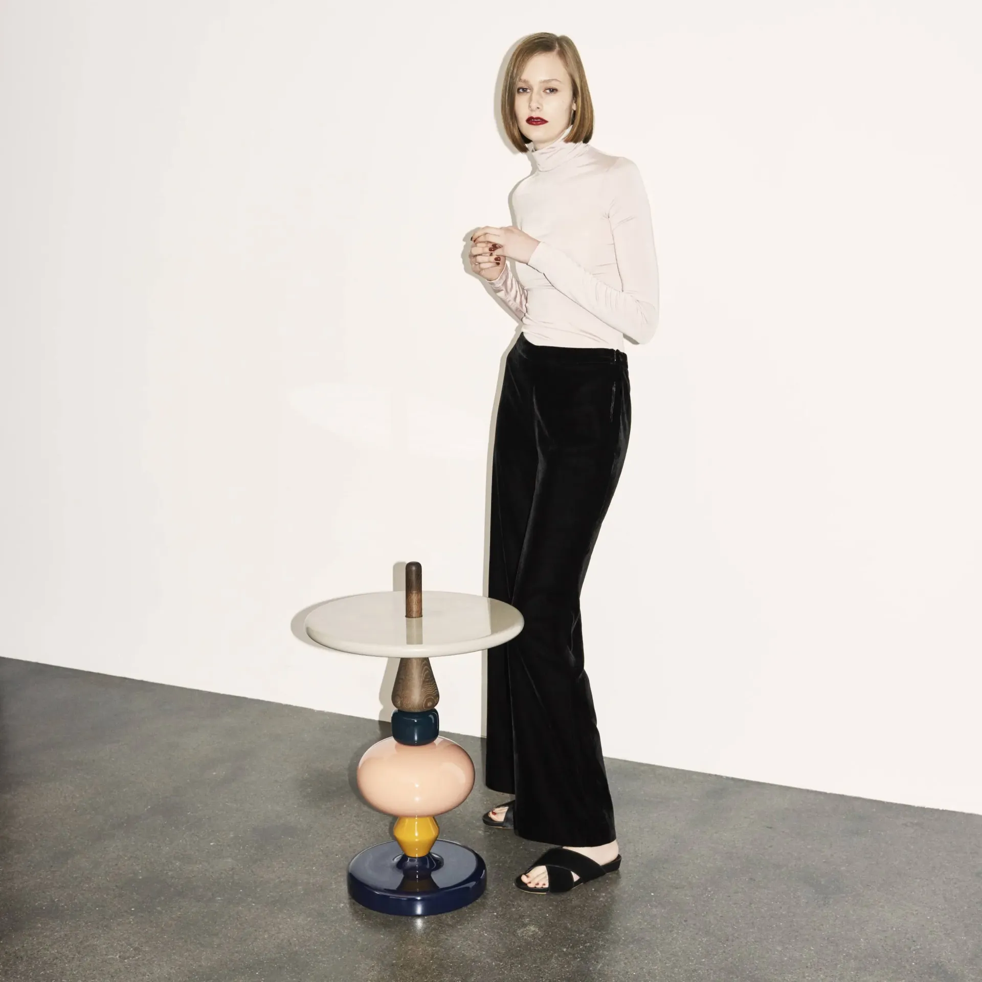 O femeie stă lângă o masă colorată