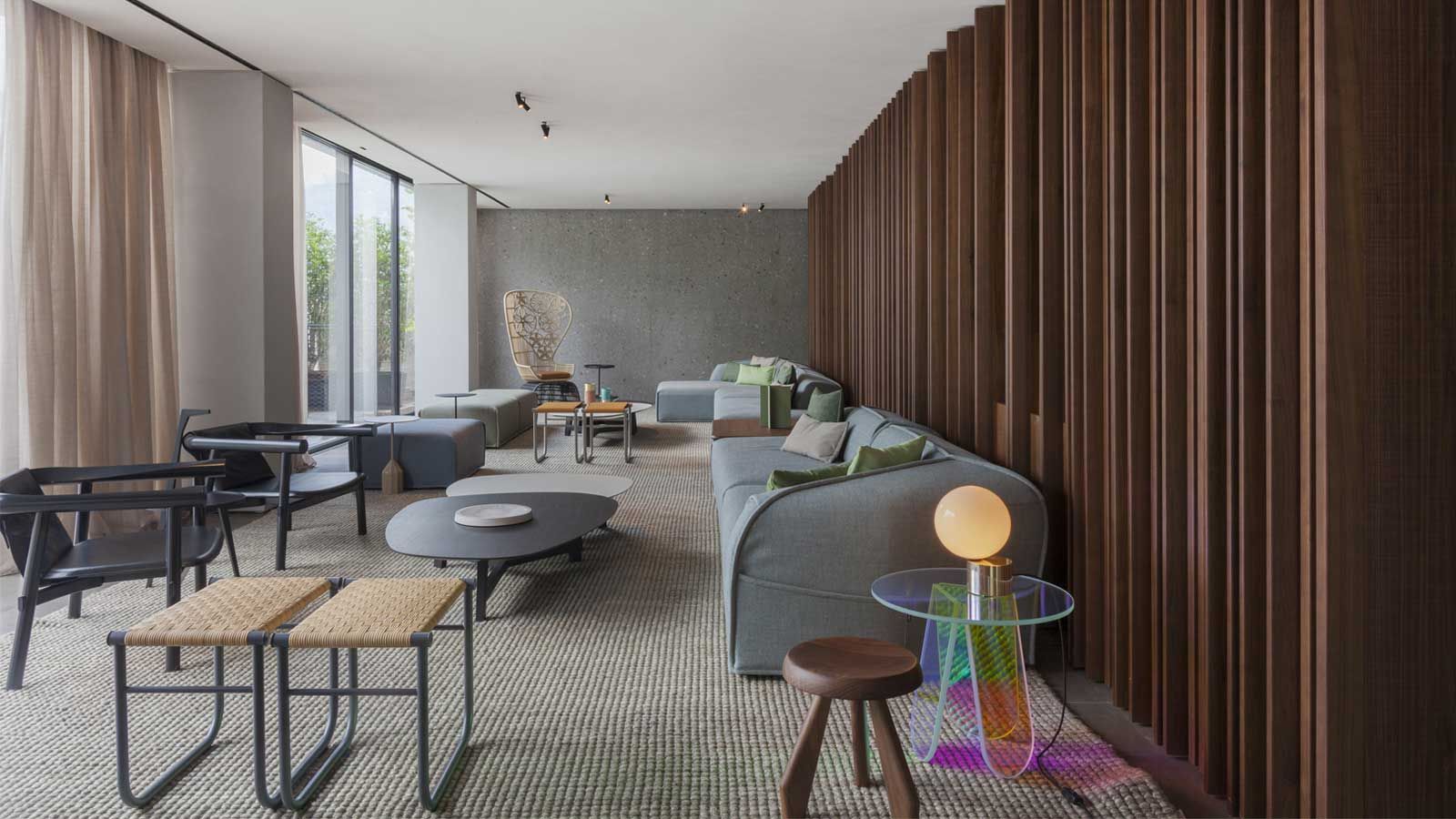 Un living plin cu mobilier si un perete de lemn.