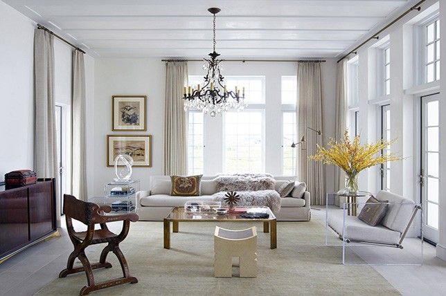 Un living cu mobilier alb si un candelabru