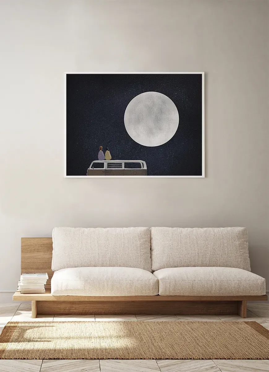 O sufragerie cu o canapea și o poză cu o lună plină pe perete.