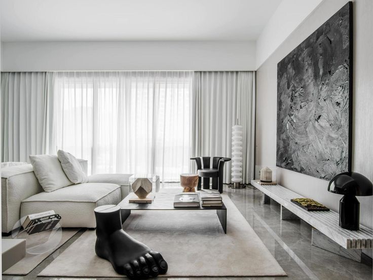 Un living cu o canapea, măsuță de cafea și un tablou mare pe perete.