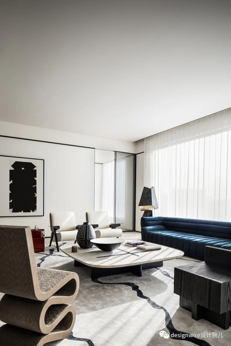 Un living cu o canapea, scaune și o masă.