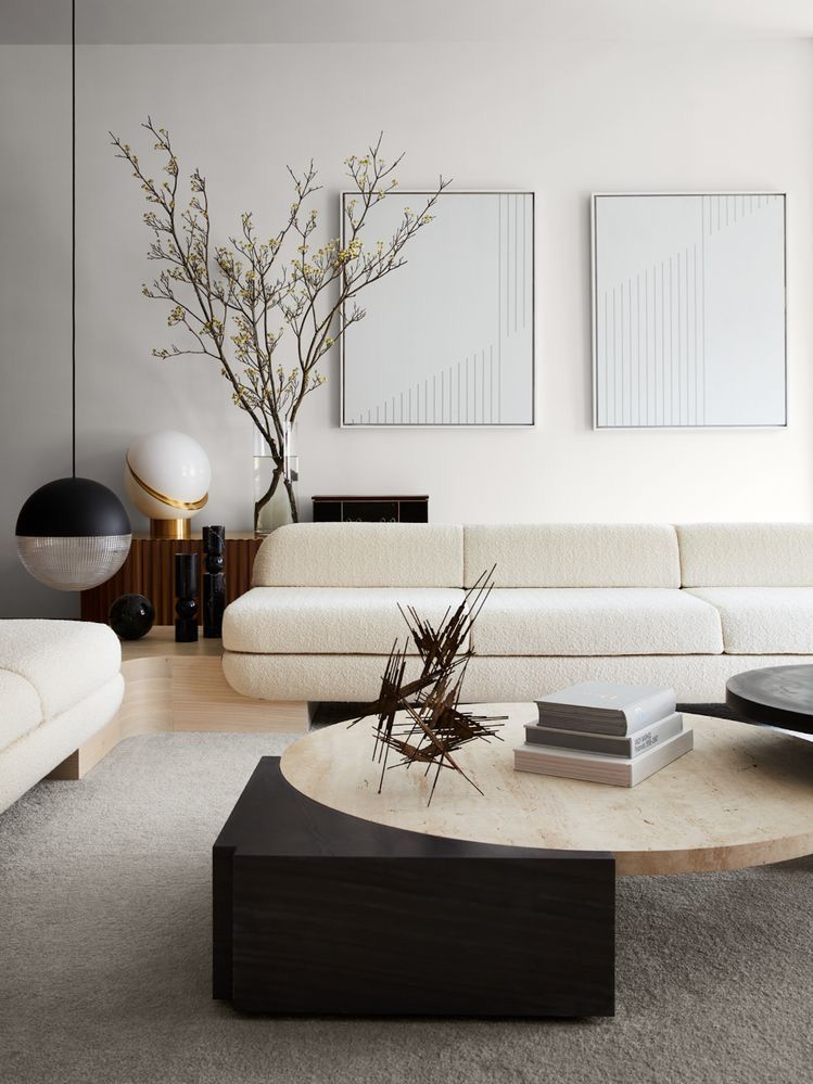 Un living cu o canapea, măsuță de cafea și tablouri pe perete.