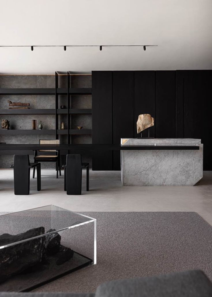 Un living cu un birou de marmură și o măsuță de cafea din sticlă