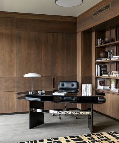 Un birou de acasă cu un birou negru și un scaun negru.