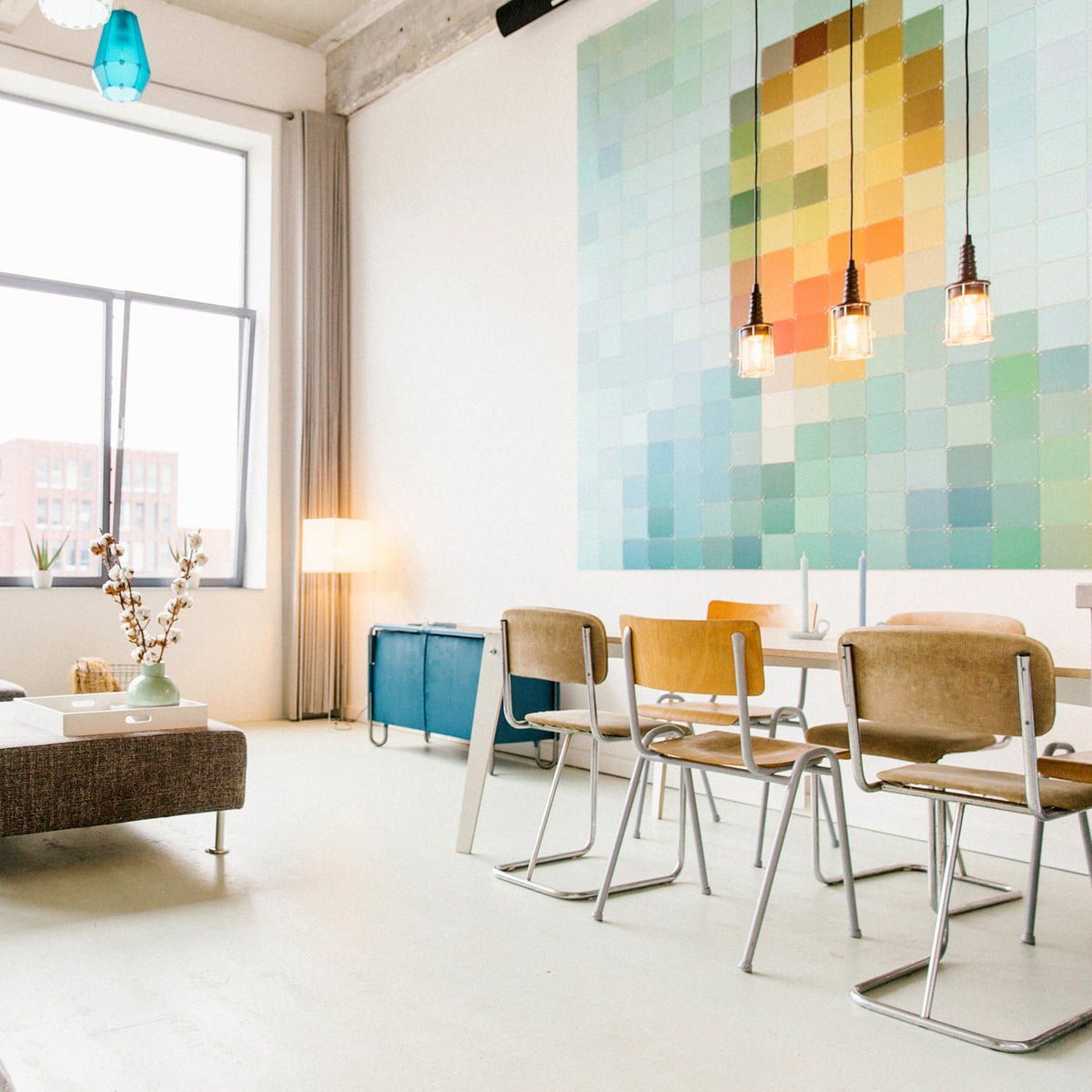 Un living cu o masă și scaune și un tablou pe perete