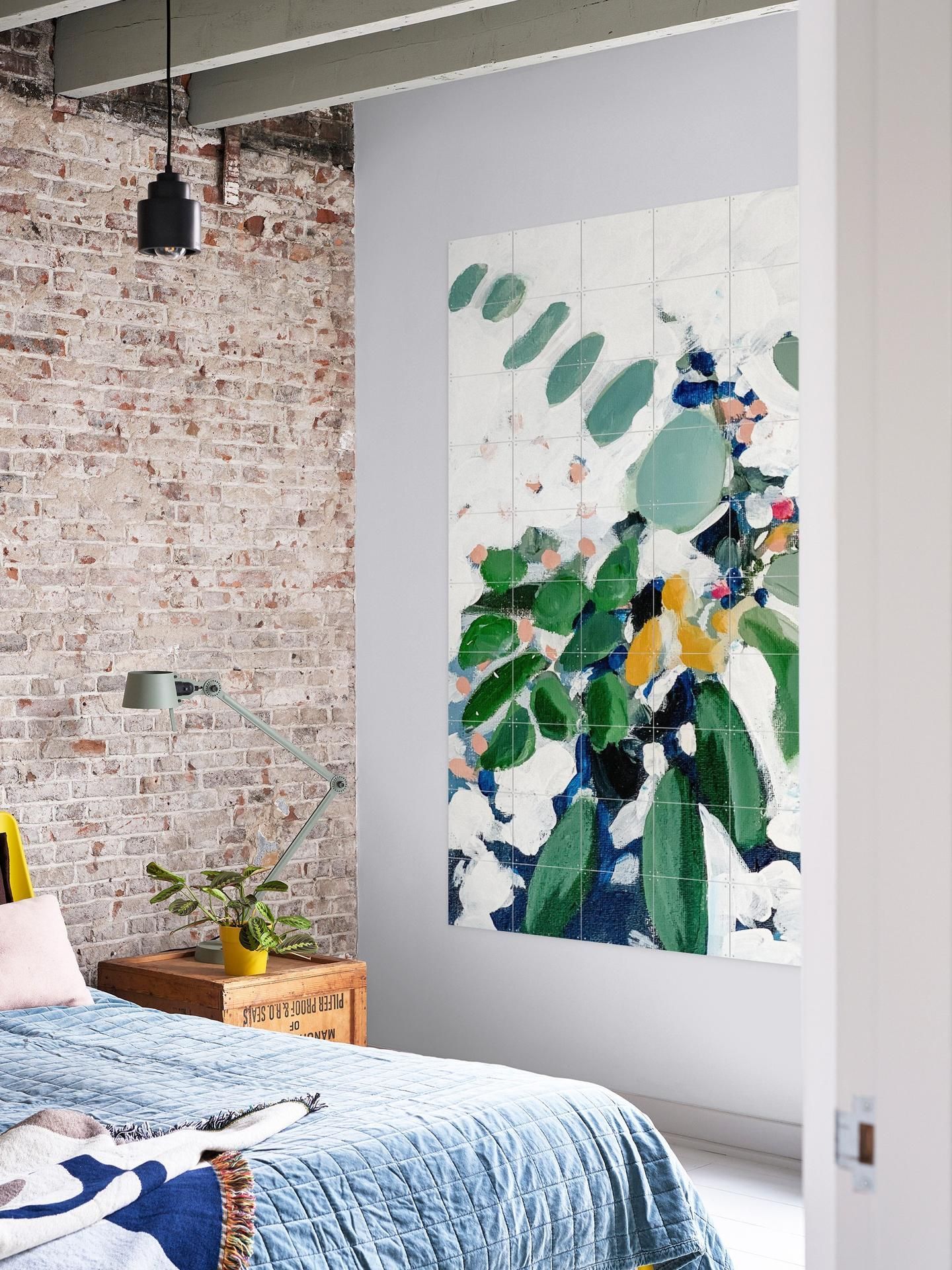 Un dormitor cu un tablou mare pe peretele de deasupra patului