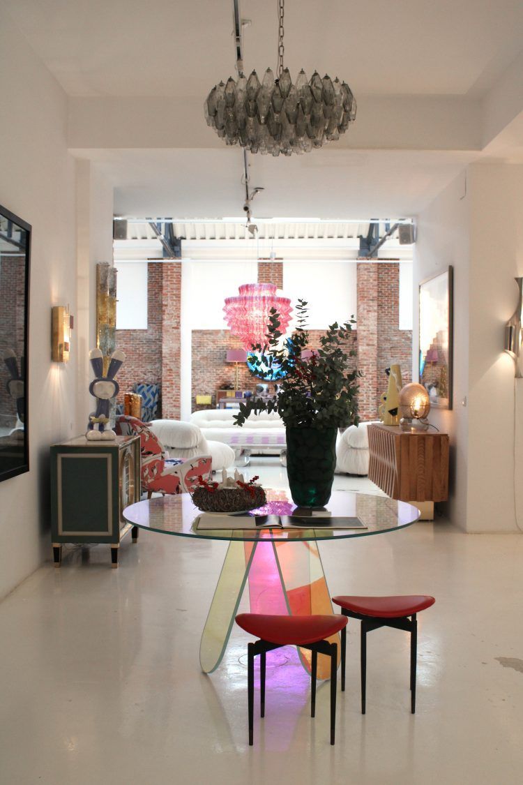 Un living cu o masă de sticlă și două scaune roșii