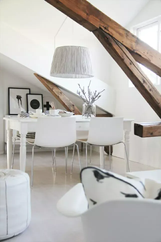 O sufragerie cu o masă și scaune sub tavan cu grinzi de lemn