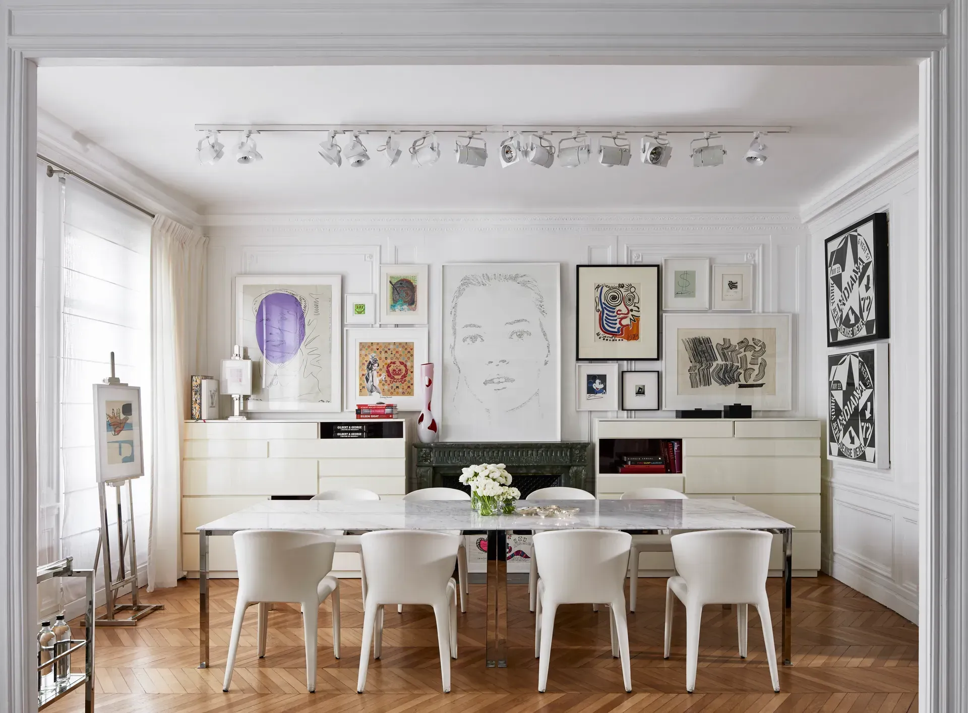 O sufragerie cu o masă și scaune și picturi pe perete