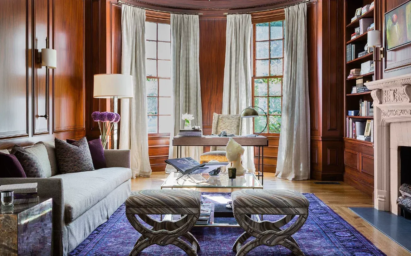 Un living cu o canapea, măsuță de cafea, pouf și un șemineu.