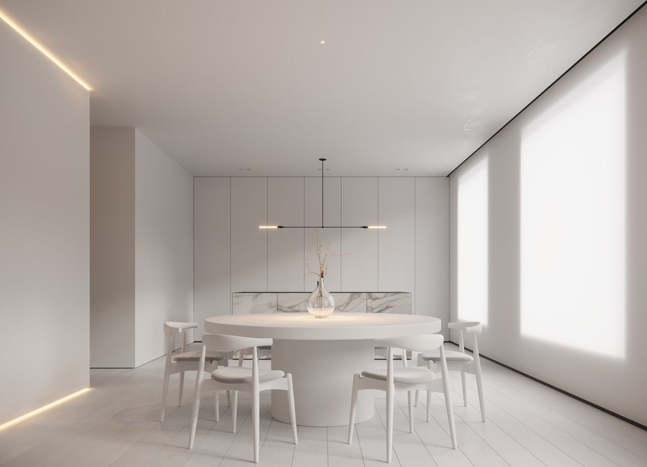 O sufragerie albă cu o masă rotundă și scaune