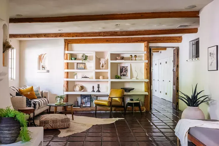 O cameră de zi cu o canapea, scaune și un raft cu cărți.