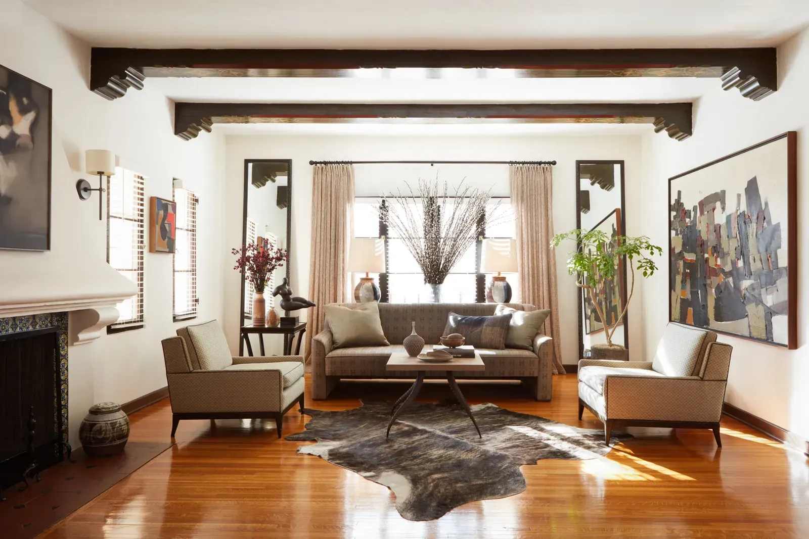 Un living cu o canapea , doua scaune , un covor si un semineu.