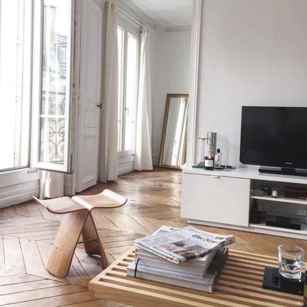 Un living cu o masă din lemn, scaun, televizor și oglindă.