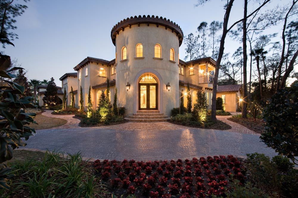 O casă mare cu o mulțime de ferestre și flori în fața ei