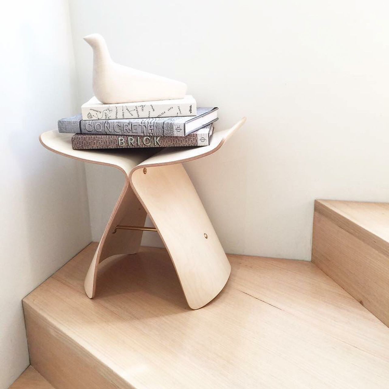 Un teanc de cărți stă deasupra unui taburet de lemn