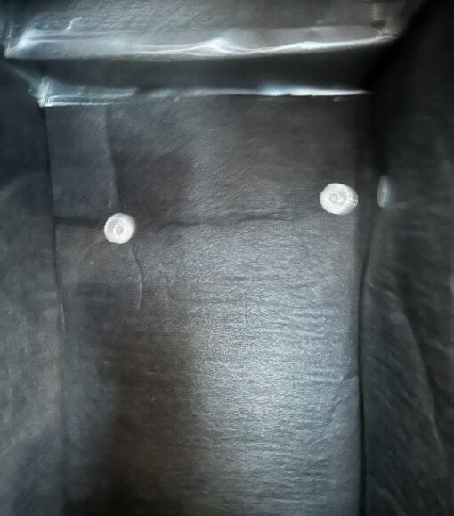 Inside a black container, three white clips are visible against the dark fabric.