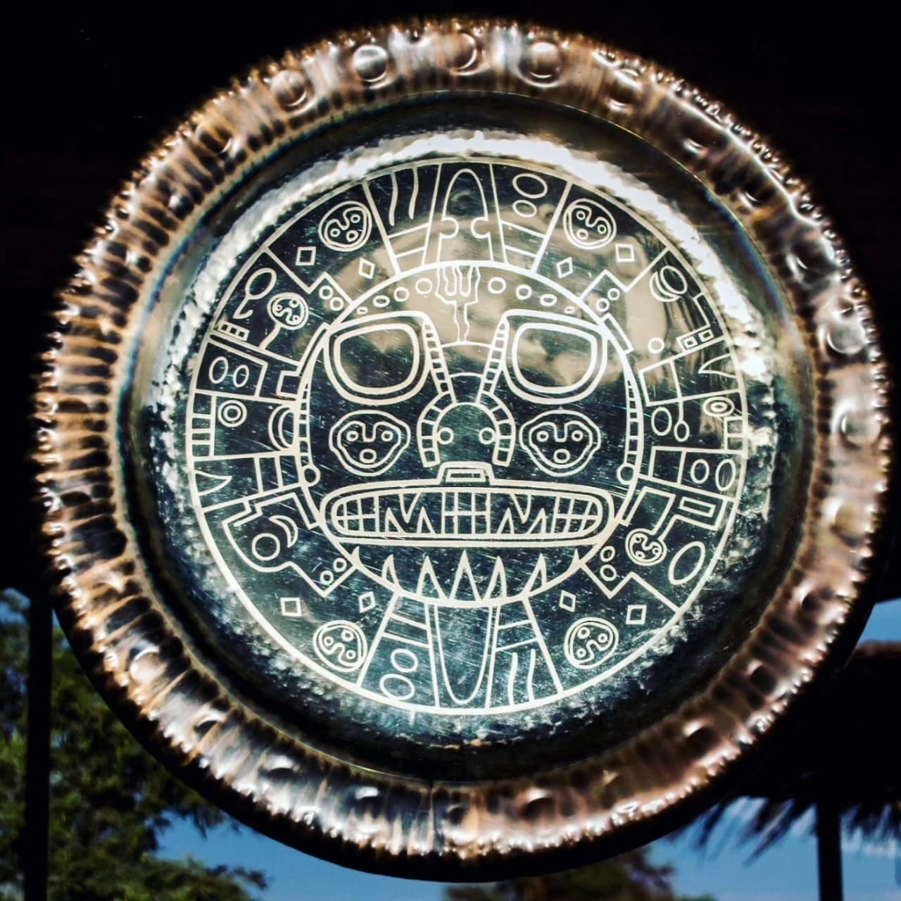 Gong de bronce con cara grabada del dios del sol inca.