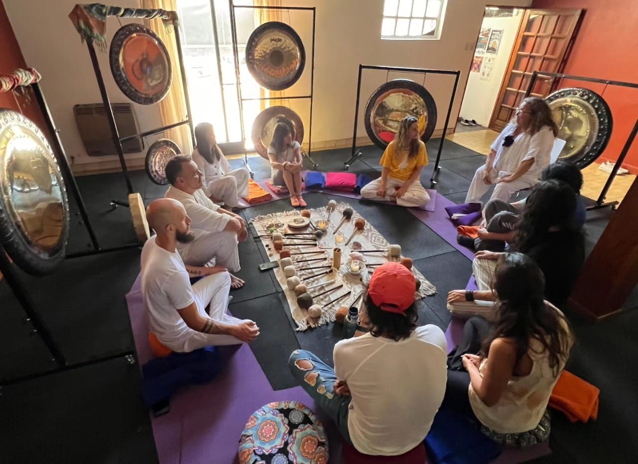 Encuentro de la Formación de trabajo terapéutico con gongs. Circulo de personas sentadas en ronda em el suelo y rodeadas de gongs.