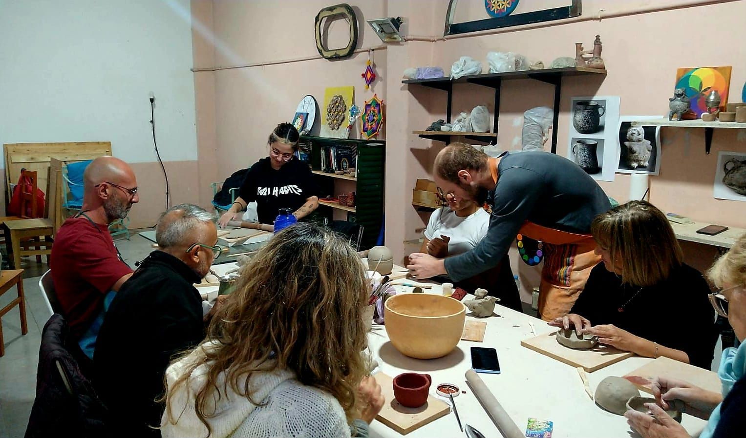 Profesor y alumnos compartiendo una clase de cerámica