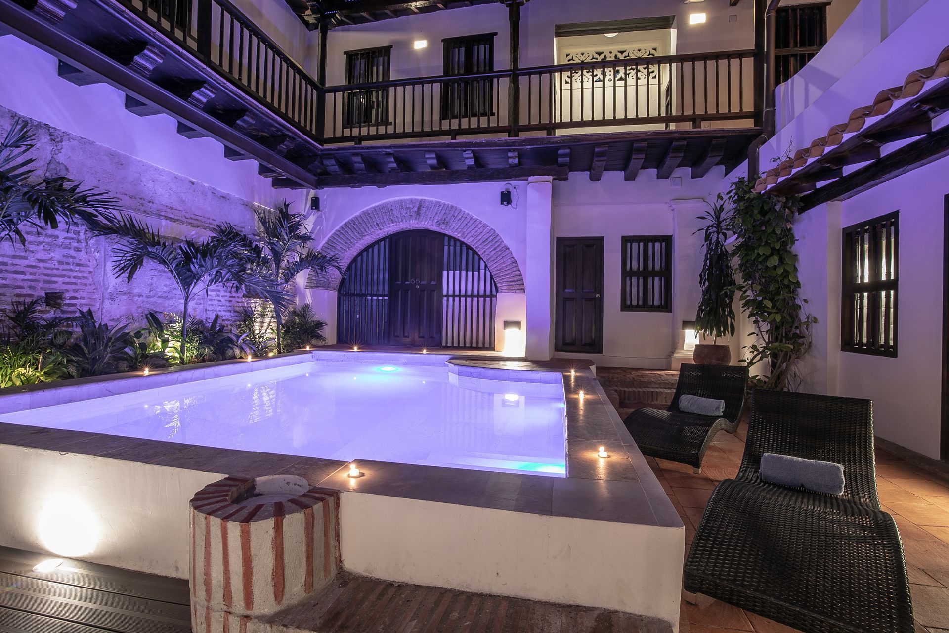 There is a large swimming pool in the middle of a courtyard.