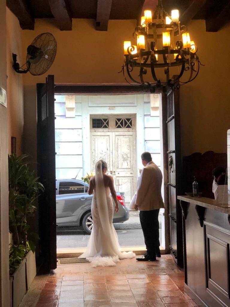 A bride and groom are standing in the doorway of a building.