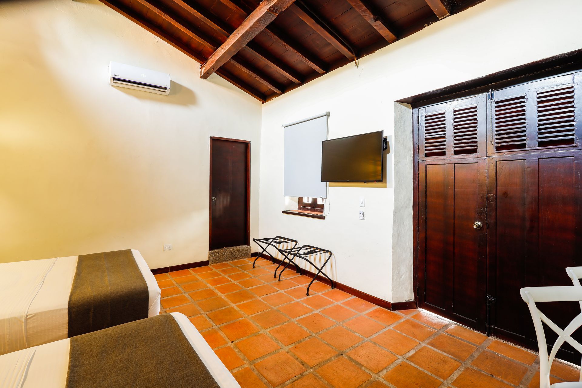 A hotel room with two beds and a flat screen tv.