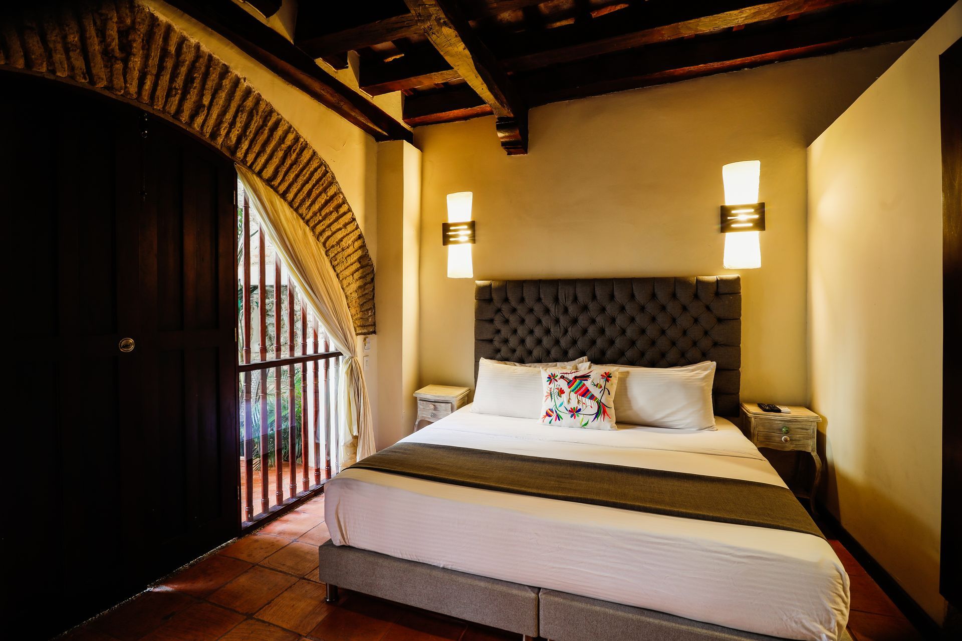 A hotel room with a king size bed and a balcony.