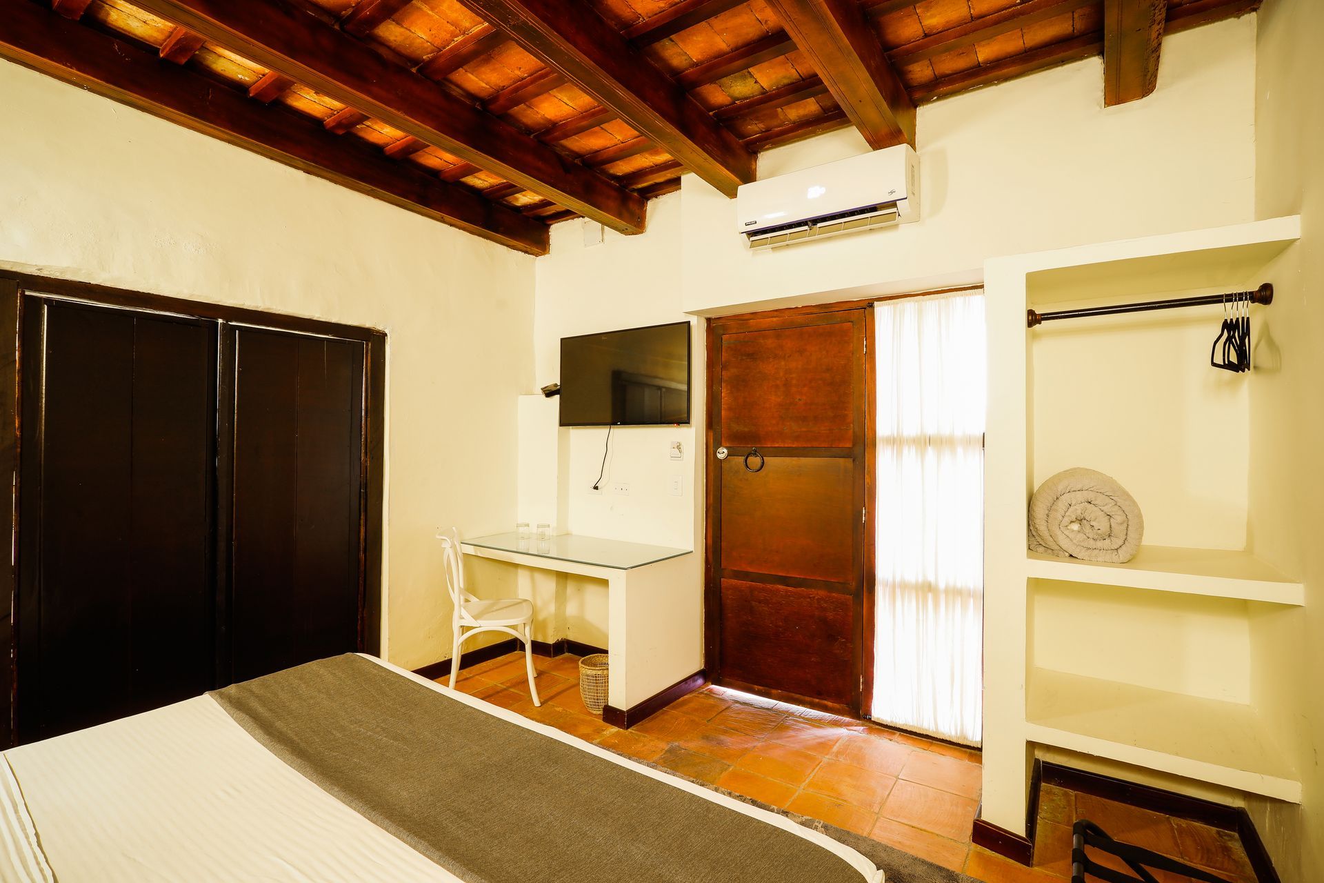 A bedroom with a bed , desk , chair and television.