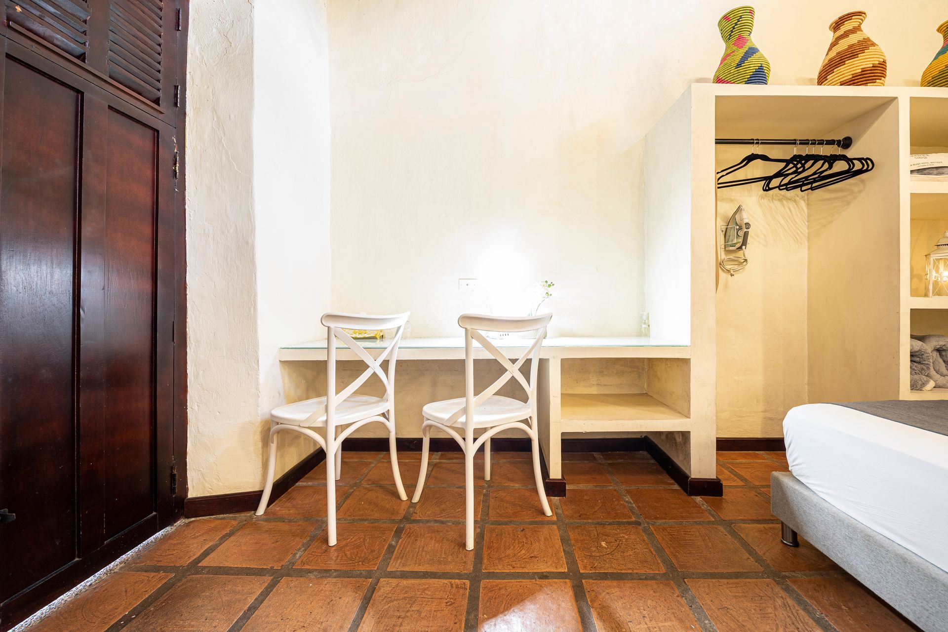 A hotel room with a bed , desk and chairs.