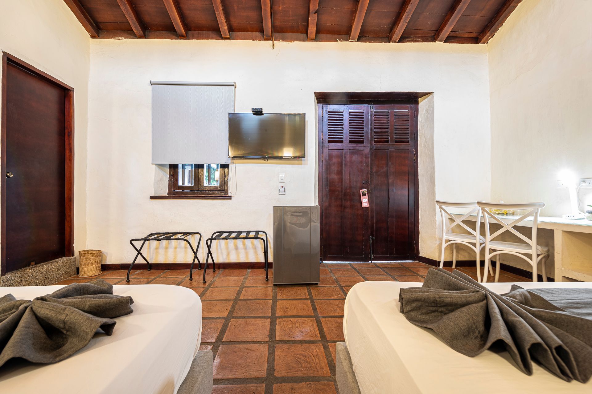A hotel room with two beds , a table and chairs.