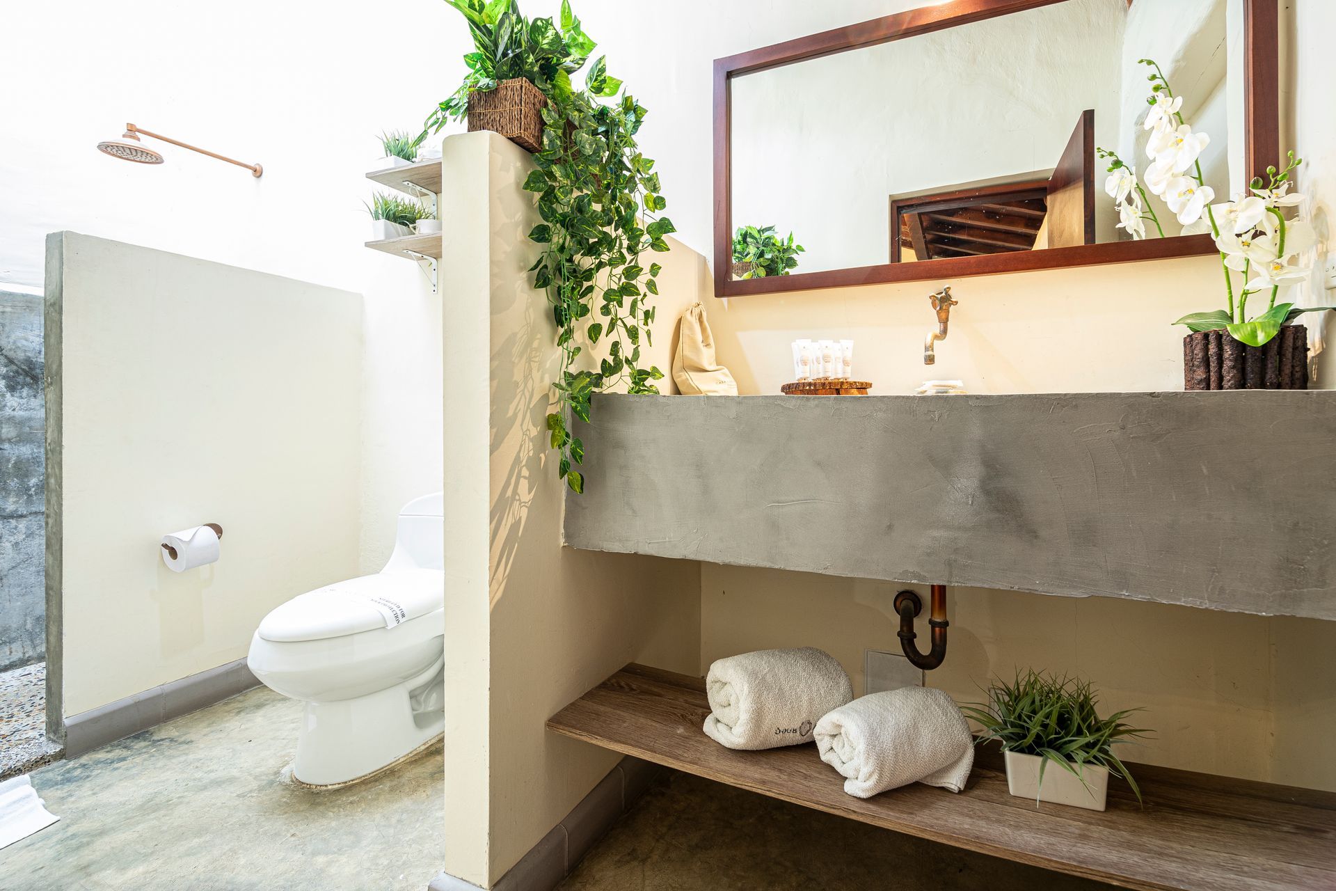 A bathroom with a toilet , sink and mirror.