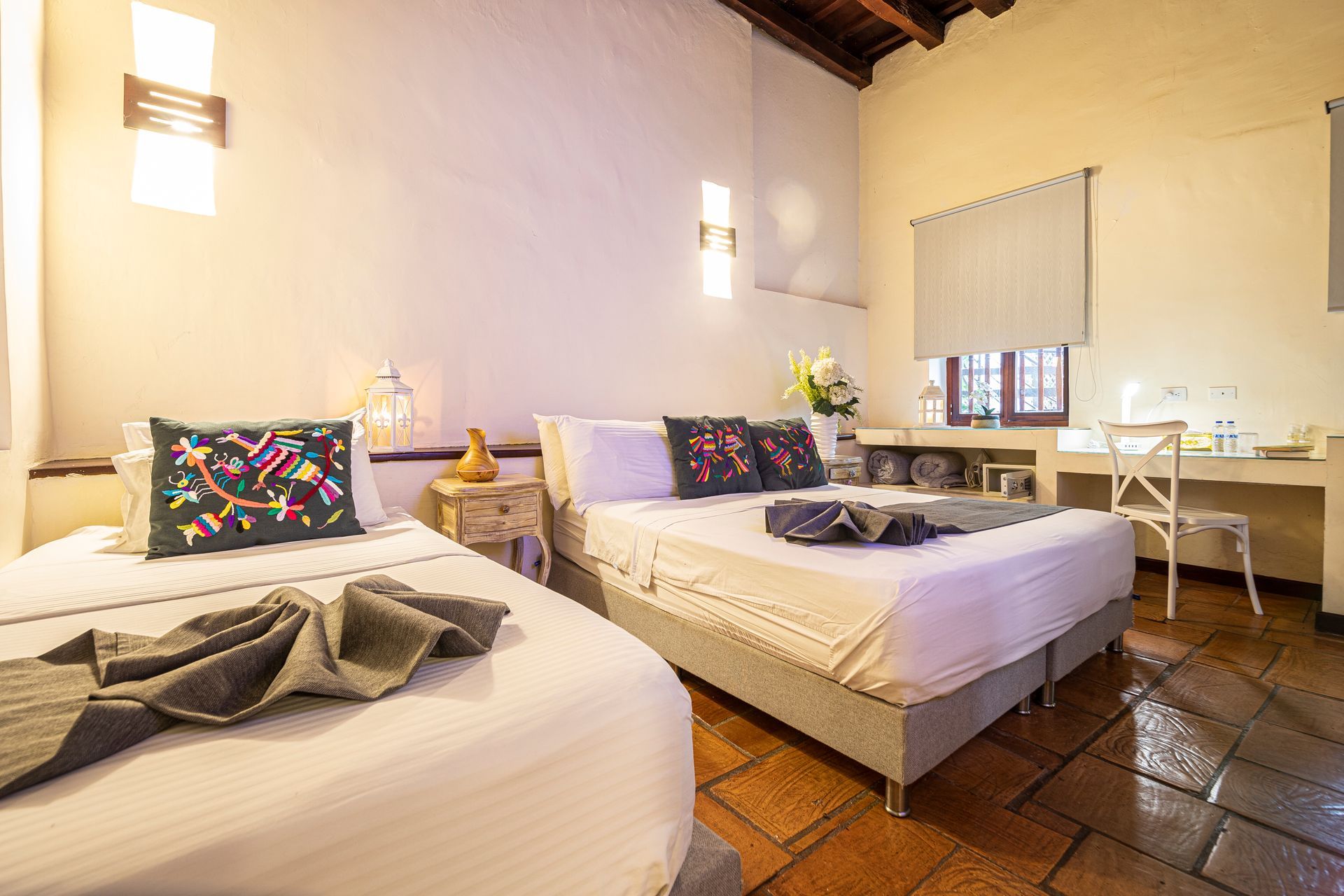 A hotel room with two beds and a desk.