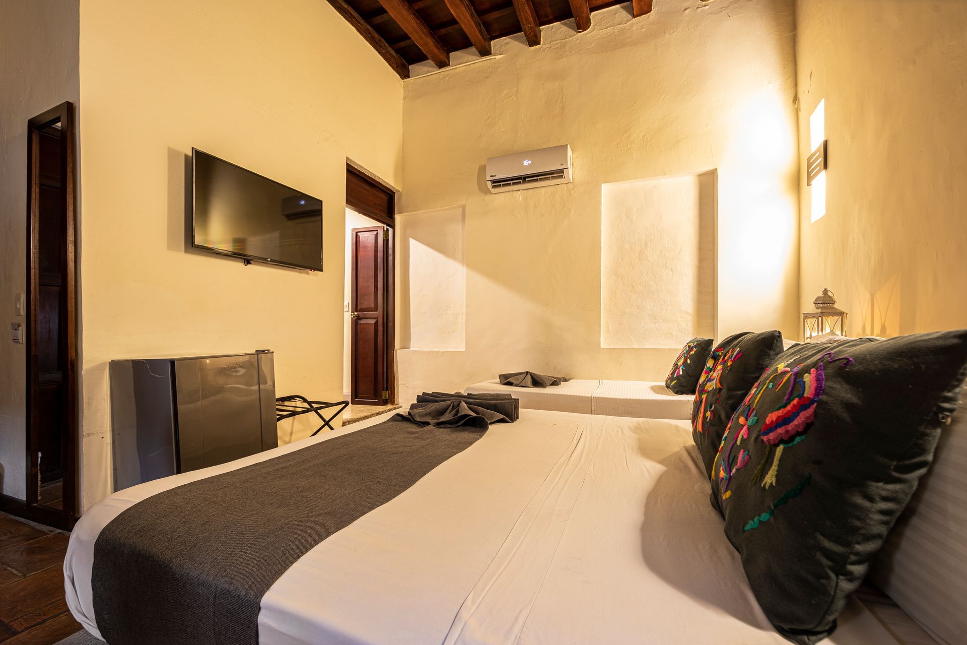 A hotel room with two beds and a flat screen tv.