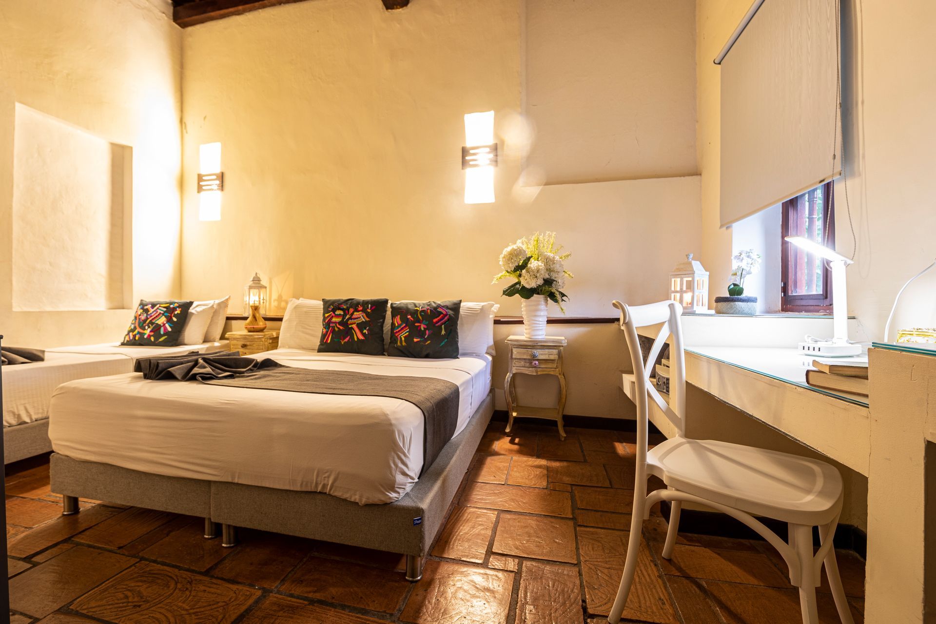 A hotel room with two beds and a desk.