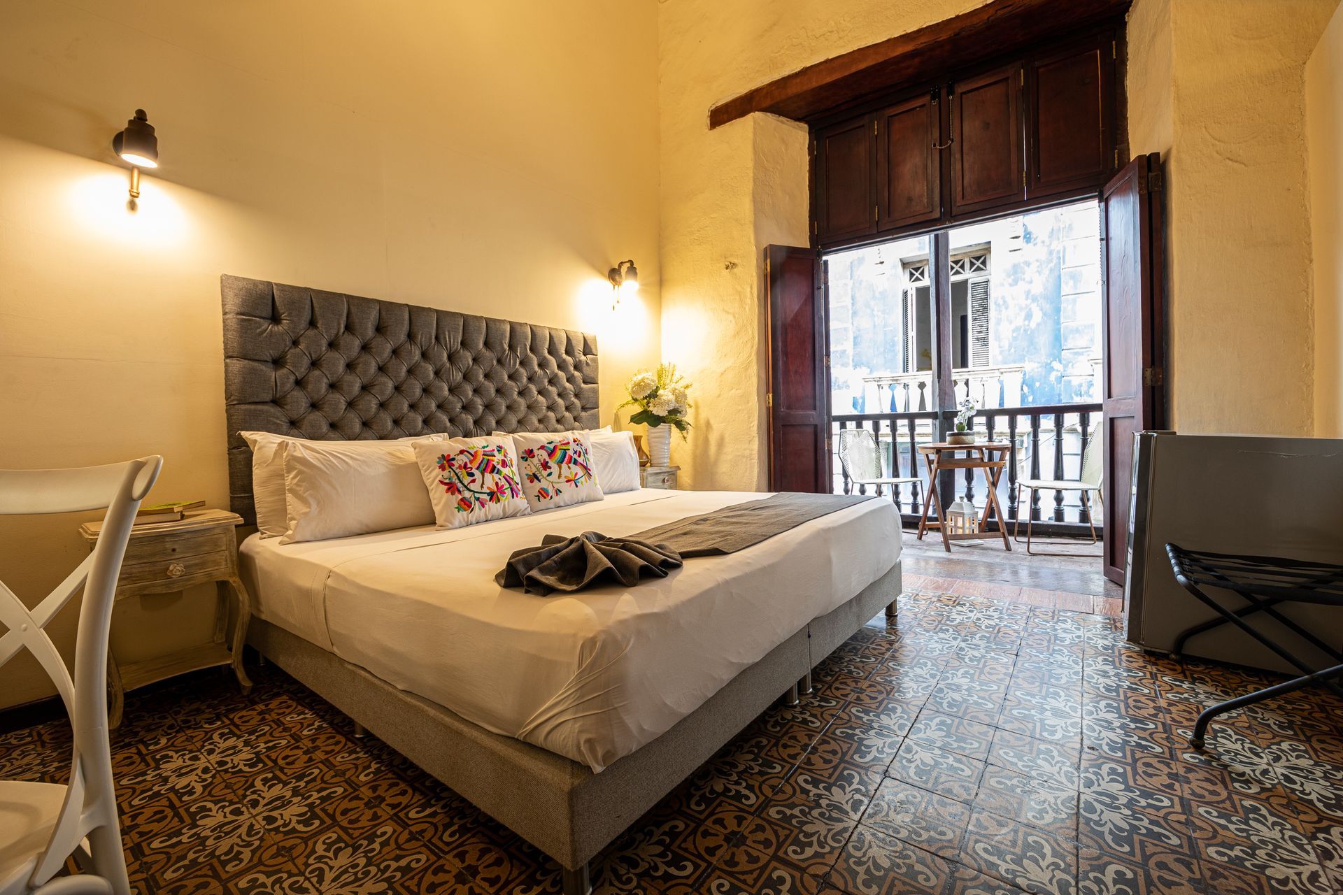 A hotel room with a large bed and a balcony.
