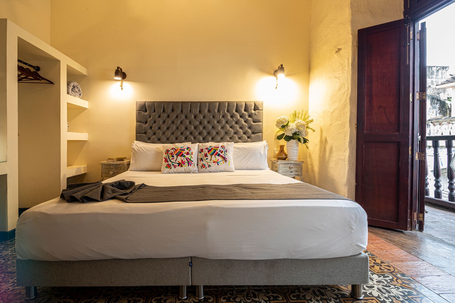 A hotel room with a king size bed and a balcony.