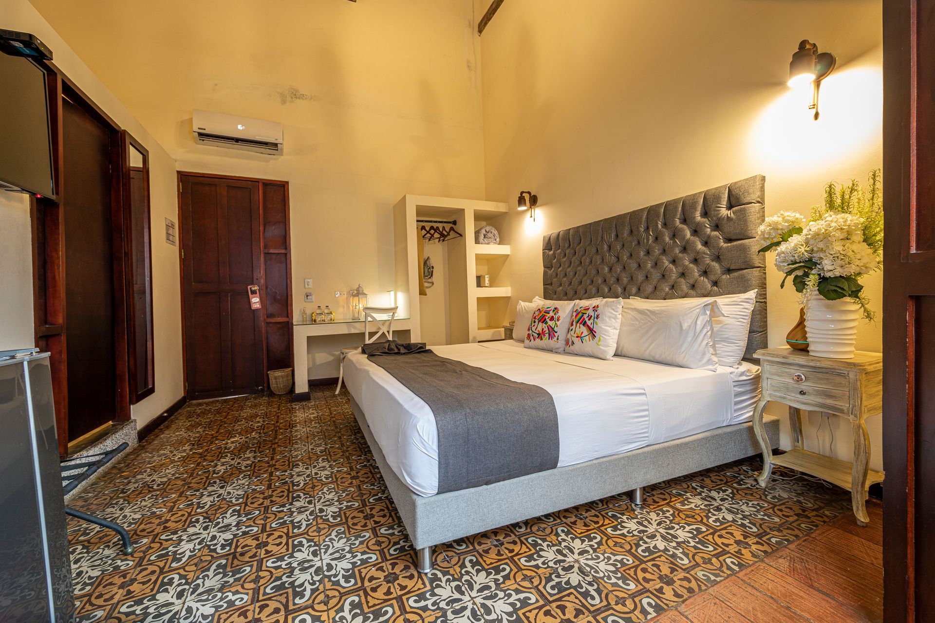 A hotel room with a king size bed , nightstand , and television.